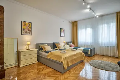 a bedroom with a bed and a dresser and window at Take One in Belgrade