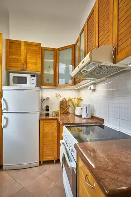 a kitchen with a white refrigerator and wooden cabinets at Take One in Belgrade