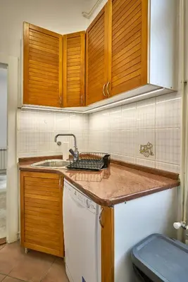 a kitchen with wooden cabinets and a sink at Take One in Belgrade
