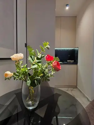 a vase with red roses sitting on a glass table at Sotto Il Sole in Surčin
