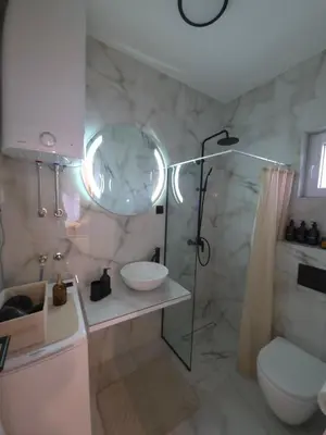 a bathroom with a shower and a toilet and a sink at Sotto Il Sole in Surčin