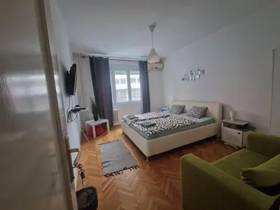 a bedroom with a bed and two chairs and a window at Urban Stay Balkanska in Belgrade