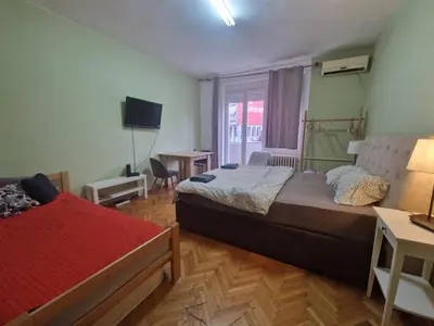 a bedroom with two beds and a television in it at Urban Stay Balkanska in Belgrade