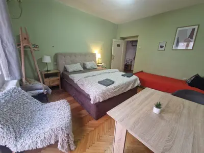 a bedroom with a bed and a table and a chair at Urban Stay Balkanska in Belgrade