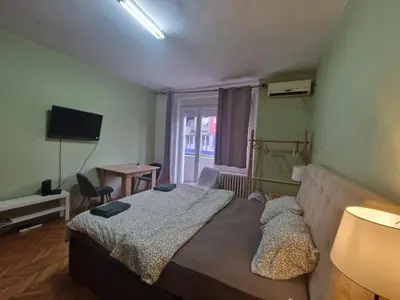 a bedroom with a bed and a television and a window at Urban Stay Balkanska in Belgrade