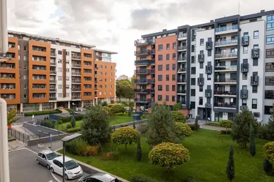 an apartment complex with cars parked in a parking lot at Osmica New Belgrade in Bežanija