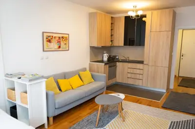 a living room with a couch and a kitchen at Osmica New Belgrade in Bežanija