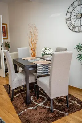 a dining room table with white chairs and a black table at Osmica New Belgrade in Bežanija