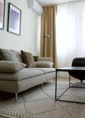 a living room with a couch and a table at Aura Apartment - with Garage Parking in Belgrade