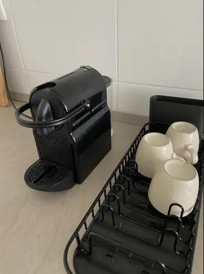 a black coffee maker with three cups on a tray at Aura Apartment - with Garage Parking in Belgrade