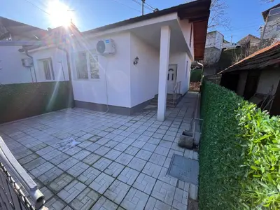 a small white house with the sun shining behind it at Apartman Tas in Smederevo