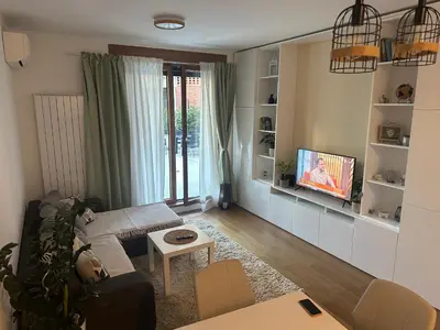 a living room with a couch and a tv at Garden Escape Zemun in Belgrade