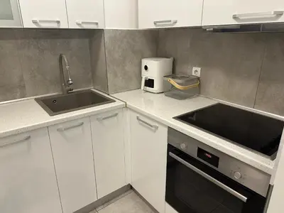 a kitchen with white cabinets and a sink at Garden Escape Zemun in Belgrade