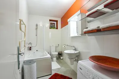 a white bathroom with a sink and a toilet at Apartments Villa Graf in Smederevo