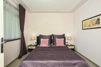 a bedroom with a large bed with pink pillows at Apartments Villa Graf in Smederevo