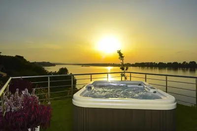 a hot tub with the sunset in the background at Apartments Villa Graf in Smederevo