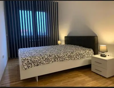 a bedroom with a bed and a large window at Royal Residence aprtamani Aviv in Pančevo