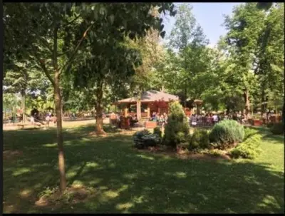 a park with trees and a gazebo in the background at Royal Residence aprtamani Aviv in Pančevo