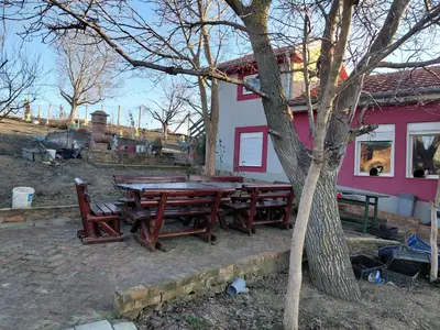 a picnic table and chairs in front of a house at Ranč Petar Alavanja Banstol in Sremski Karlovci
