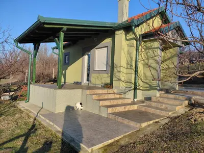a small house with stairs and a dog in front of it at Ranč Petar Alavanja Banstol in Sremski Karlovci