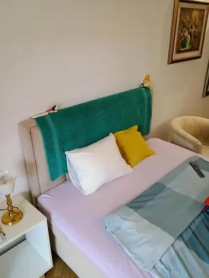 a bed with a green headboard in a room at H1trece in Belgrade