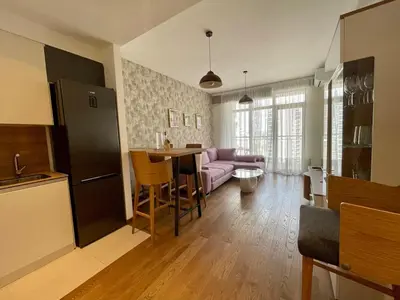 a kitchen and living room with a couch and a table at Romantic One Bedroom Home at BW-City and Park View in Belgrade