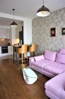 a living room with a purple couch and a table at Romantic One Bedroom Home at BW-City and Park View in Belgrade