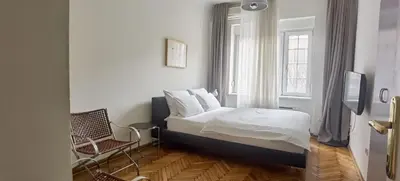 a bedroom with a bed and a window and a chair at Two Bedroom Apartment Obilicev Venac in Belgrade