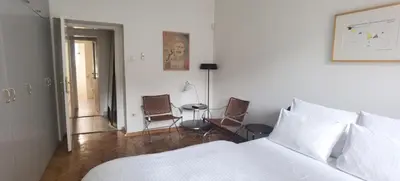 a bedroom with a bed and a table and chairs at Two Bedroom Apartment Obilicev Venac in Belgrade
