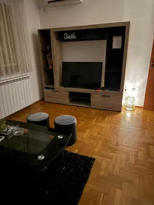 a living room with a flat screen tv and a table at Barbello in Stara Pazova