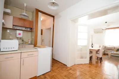 a kitchen with white cabinets and a dining room at Apartments City Hall in Belgrade