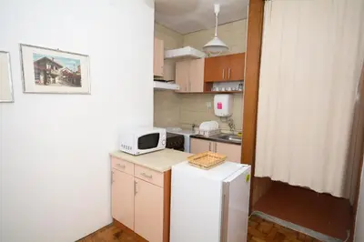 a small kitchen with a microwave on top of a refrigerator at Apartments City Hall in Belgrade