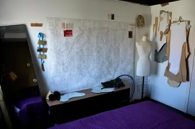 a bedroom with a bed and a wall with clothes at casa CIUK in Belgrade