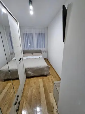 a small bedroom with a bed and a mirror at No 104 7 Residance in Belgrade