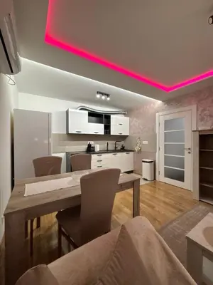 a kitchen with a dining table and a pink light at No 104 7 Residance in Belgrade