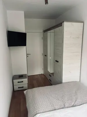 a bedroom with a bed and a large wooden cabinet at No 104 7 Residance in Belgrade