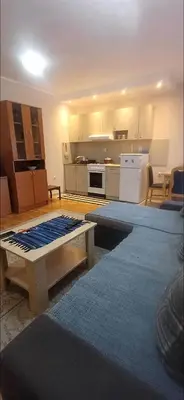 a living room with a kitchen with a table at Jelena's place in Belgrade