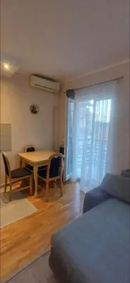 a living room with a table and chairs and a bed at Jelena's place in Belgrade