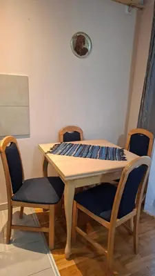 a wooden table with four chairs around it at Jelena's place in Belgrade