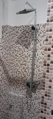 a shower head in a bathroom with a tiled wall at Flat center of Belgrade in Belgrade