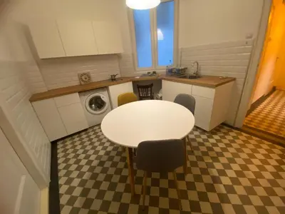 a kitchen with a table and a sink and a washing machine at Flat center of Belgrade in Belgrade