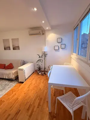 a living room with a white table and a couch at Light & Cozy Flat Banovo Brdo in Belgrade