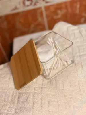 a glass container with a wooden block on a bed at Light & Cozy Flat Banovo Brdo in Belgrade