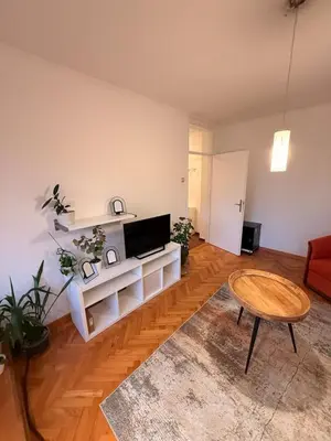 a living room with a television and a table at Light & Cozy Flat Banovo Brdo in Belgrade