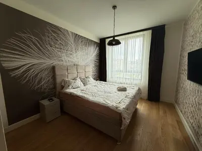 a bedroom with a bed and a large window at Eden Apratment in Belgrade