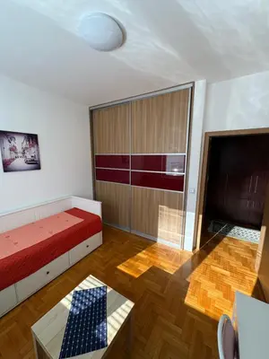 a room with a bed and a television and a table at Cozy place in Belgrade