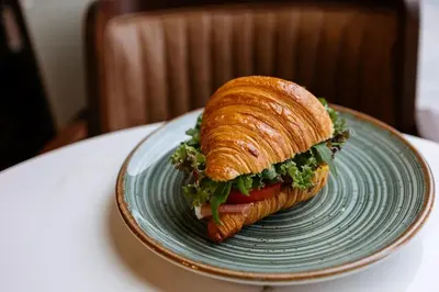 a sandwich on a blue plate on a table at BW Sole Presidential Suite in Belgrade