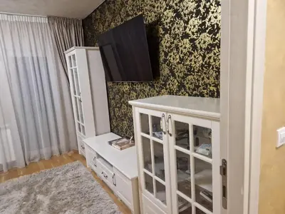 a white cabinet with a tv on a wall at Apartman Oskar Dunav in Stari Banovci