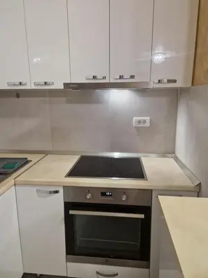 a kitchen with a stove and white cabinets at Apartman Oskar Dunav in Stari Banovci