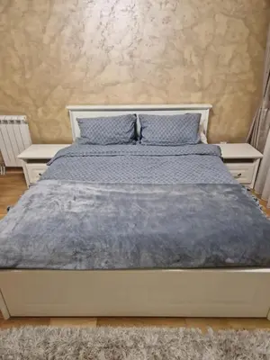 a bed with a blue blanket on top of it at Apartman Oskar Dunav in Stari Banovci